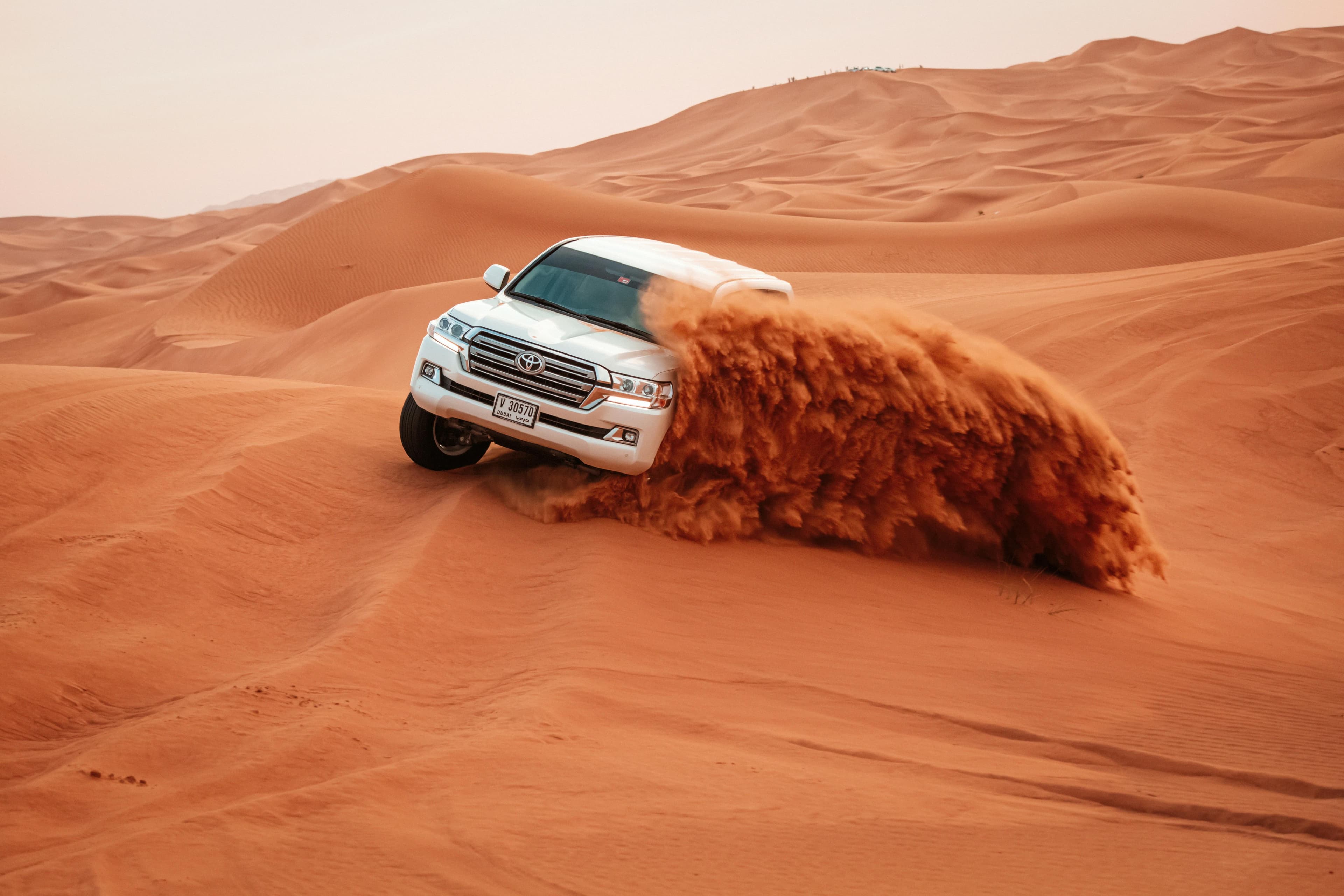 4x4 vehicle driving through desert dunes